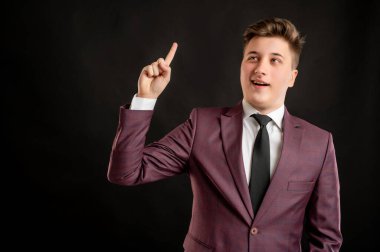 Sarı saçlı, bordo ceketli, beyaz gömlekli ve siyah kravatlı bir hukuk öğrencisi, siyah arka planda fotokopi alanının reklamcılığını yapan bir fikir buldu.