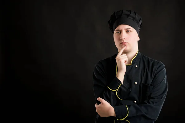 Portret Młodego Mężczyzny Ubranego Czarny Strój Szefa Kuchni Trzymającego Rękę — Zdjęcie stockowe