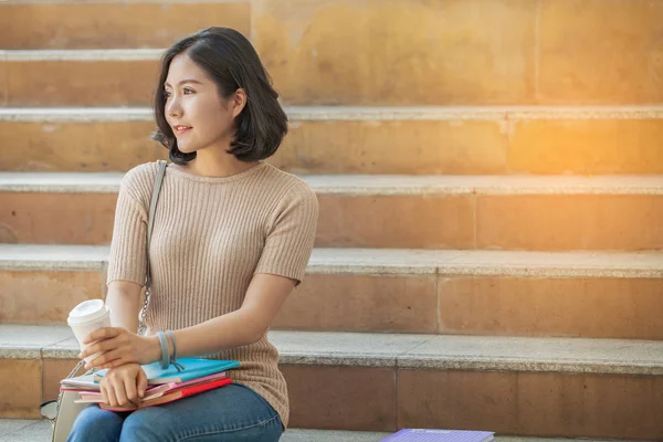 Kitaplarını ve merdiven, insanlar eğitim yüksek okulu programı akıllı genç kavramı öğrenme oturmuş kahve bir fincan güzel Asya Bayan üniversite öğrencisi
