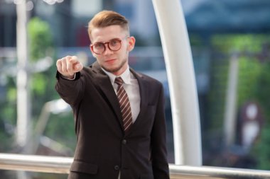 Kendine güvenen iş adamı. Açık havada duran ise tam takım tump kadar kendine güvenen genç adam