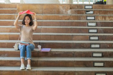 Kitaplarını ve merdiven, insanlar eğitim yüksek okulu programı akıllı genç kavramı öğrenme oturmuş kahve bir fincan güzel Asya Bayan üniversite öğrencisi
