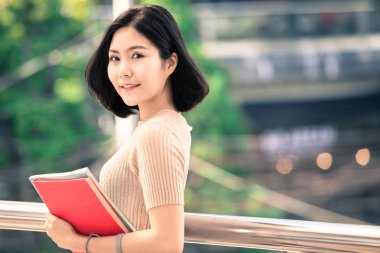 Güzel Asyalı kadın üniversite öğrencisi lise programı akıllı genç kavram öğrenme insanlar eğitim kitaplarını gülümseyerek mutlu bir şekilde açık, ayakta tutan