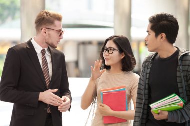 İşadamı ve üniversite öğrencileri Eğitim açık arka plan üzerinde tartışıyor
