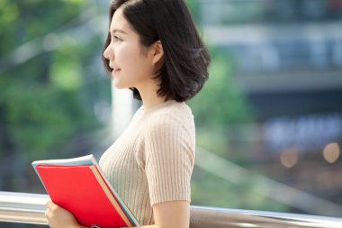 Güzel Asyalı kadın üniversite öğrencisi lise programı akıllı genç kavram öğrenme insanlar eğitim kitaplarını gülümseyerek mutlu bir şekilde açık, ayakta tutan