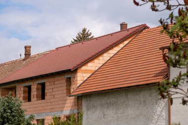 Eski bir evin yeniden inşası ve genişletilmesi, turuncu tuğla yapı ve çatı onarımı