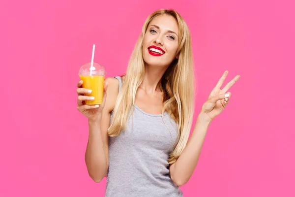 Joven Chica Hermosa Con Fondo Rosa Sosteniendo Jugo Naranja Sonriendo — Foto de Stock