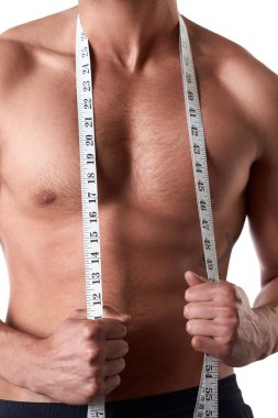 Ölçme bandı olan kaslı genç adam. Sporcu izole beyaz arka plan üzerinde ölçü tutar. Spor ve sağlıklı konsept