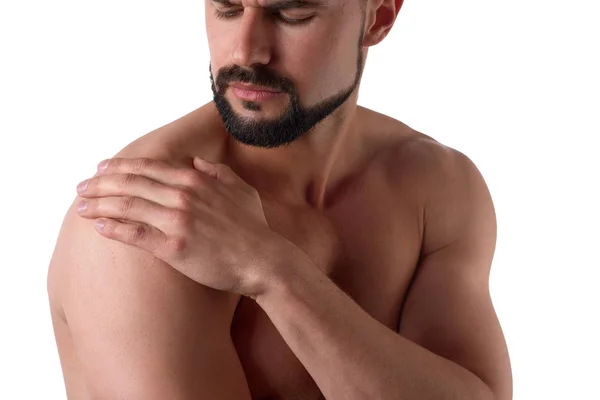 Gespierde sterke man met schouderpijn, geïsoleerd op witte achtergrond. Sportman houdt zijn zere schouder — Stockfoto