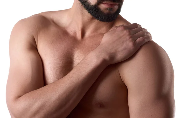 Сильный мускулистый мужчина с болью в плече, изолированный на белом фоне. Спортсмен держит больное плечо — стоковое фото