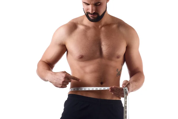 Mann mit muskulösem Körper, der seinen Bauch misst. starker muskulöser Mann auf isoliertem Hintergrund — Stockfoto