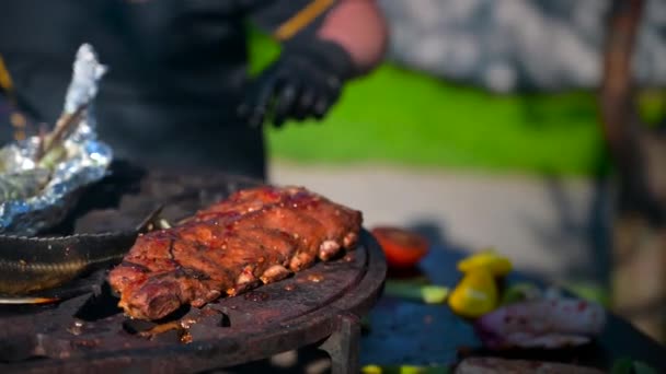 Grilled beef ribs on the barbecue, the cook prepares dinner, lunch for the whole family, grilled fish and vegetables — Stock Video