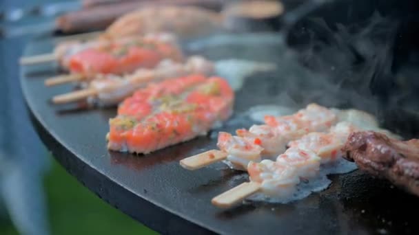 Roter Forellenfischlachs wird auf dem Grill gegrillt, ein Fischsnack im Sommer. Chef in schwarzen Nitrilhandschuhen bereitet Galadinner vor — Stockvideo