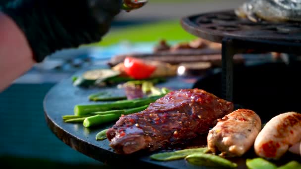 Cocine en guantes de nitrilo negro espolvorea salsa en una carne de barbacoa, carne de res en llamas, cerdo para una cena festiva, un aperitivo para la cena — Vídeos de Stock