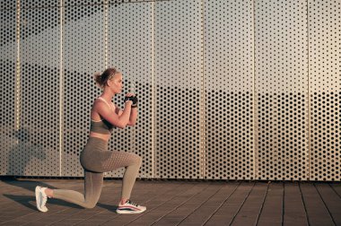 Spor giyimli güçlü bir fitness kadını dışarıda mekik çekiyor. Sportif kız egzersizi, fiziksel egzersiz, sağlıklı yaşam tarzı, motivasyon konsepti