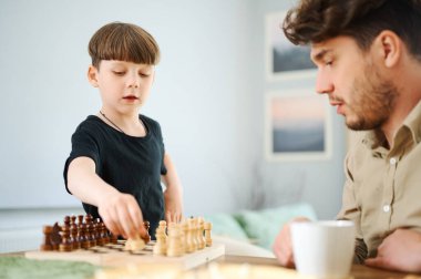 Baba oğluna satranç oynamayı öğretiyor. Eğitim ve öğretim kavramı.