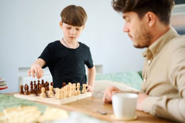 Baba oğluna satranç oynamayı öğretiyor. Eğitim ve öğretim kavramı.