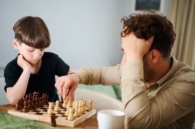 Baba oğluna satranç oynamayı öğretiyor. Eğitim ve öğretim kavramı.