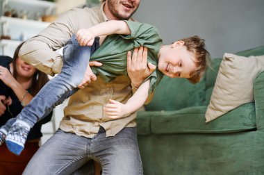Genç baba şarkıyla eğleniyor, oynuyor ve evde gülüyor. Mutlu aile birlikte vakit geçiriyor.