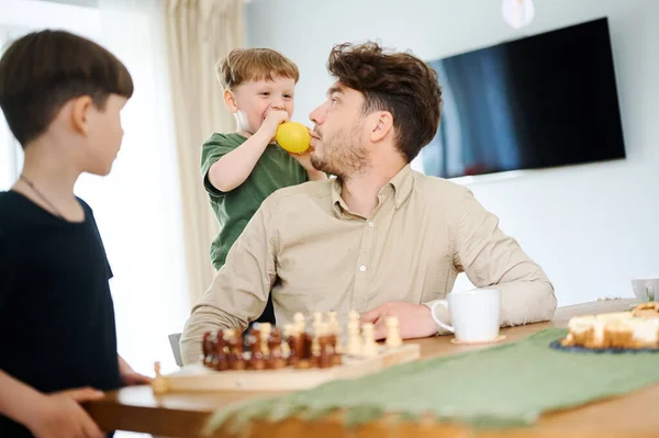 Père enseignant aux fils comment jouer aux échecs. Concept d'éducation et d'enseignement. — Photo