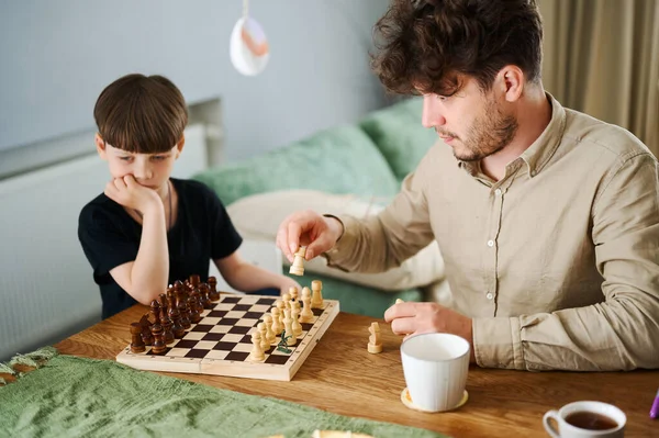 Père enseignant aux fils comment jouer aux échecs. Concept d'éducation et d'enseignement. — Photo