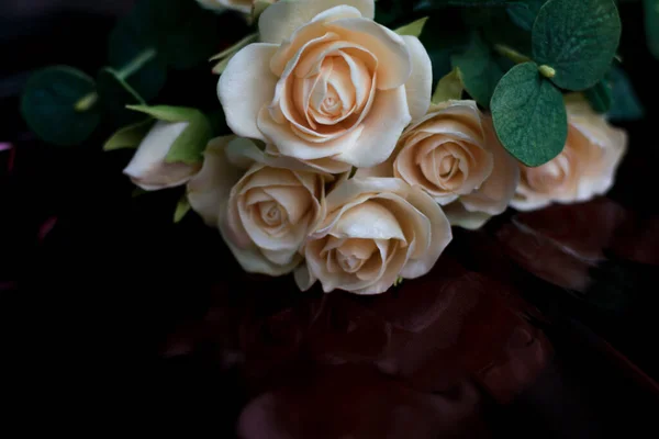 Bukiet kremowych róż w sprayu z eukaliptusem na ciemnoczerwonym musującym i refleksyjnym tle. Tło Walentynki, Dzień Matki, koncepcja rocznicy — Zdjęcie stockowe