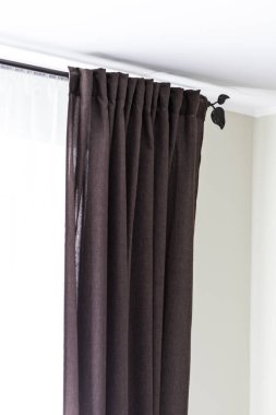 Dark brown curtains in the bedroom with patterned metal curtains clipart