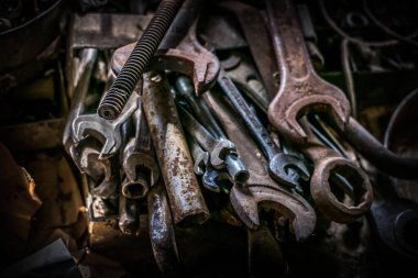 El aletleri seti eski, paslı metal. Masanın üzerinde çeşitli şekillerde anahtarların yanı sıra dosyalar, civatalar, fındıklar, ayarlanabilir anahtarlar var.