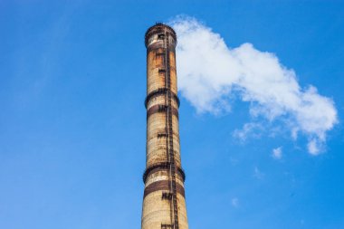 Mavi gökyüzüne karşı endüstriyel fabrika dumanı yığını