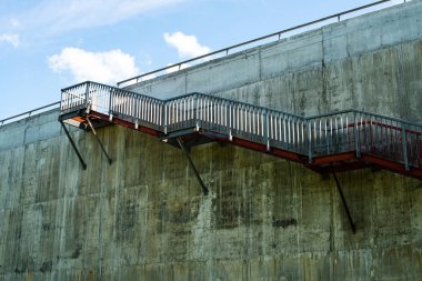 Gri beton duvardaki metal merdivenler..