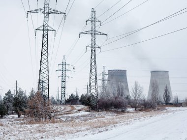 Kyiv (Ukrayna) yakınlarındaki kojenerasyon fabrikasının elektrik direkleri, elektrik hatları ve soğutma kuleleri.