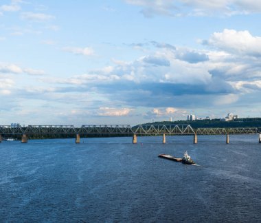 Mavi Dinyeper sularında yüzen mavna yazın Kyiv manzarasına karşı.
