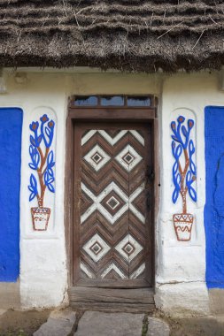 Kapı wattle and daub tekniği thatched çatı ile inşa edilen eski geleneksel Ukrayna ev dekore edilmiş.