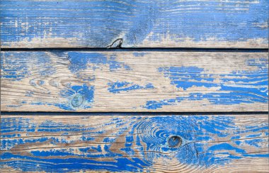 Üzerinde mavi boya kalıntıları olan eski ahşap yüzey.