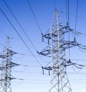 Mavi gökyüzüne karşı elektrik direklerinin sistemi.