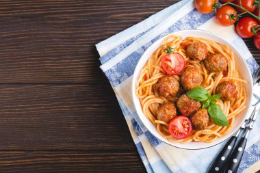 İtalyan asıllı ABD'li geleneksel çanak köfte, domates sosu ve fesleğen kase, rustik ahşap arka plan, üstten görünüm, kopya alanı spagetti. Yakın çekim köfte geçmiş