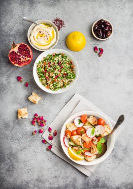 Orta Doğu/Arapça yemekleri ve meze, beton rustik arka plan. Soğanlı ekmek salata, tabbouleh, Humus, zeytin, pide, nar. Helal Gıda. Lübnan mutfağı. Orta Doğu yemek. Üstten görünüm