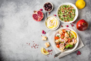 Orta Doğu/Arapça yemekleri ve meze, beton rustik arka plan. Metin için yer. Soğanlı salata, tabbouleh, Humus, zeytin, pide ekmek. Helal Gıda. Lübnan mutfağı. Orta Doğu yemek. Üstten görünüm