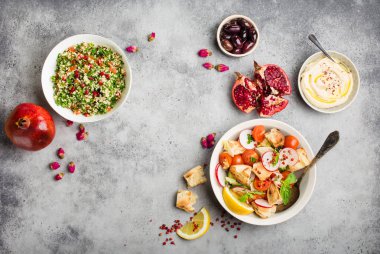 Orta Doğu/Arapça yemekleri ve meze, beton rustik arka plan. Metin için yer. Soğanlı salata, tabbouleh, Humus, zeytin, pide ekmek. Helal Gıda. Lübnan mutfağı. Orta Doğu yemek. Üstten görünüm