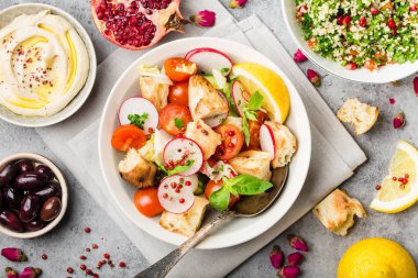 Soğanlı ekmek salata. Orta Doğu/Arapça geleneksel çanak, beton rustik arka plan. Soğanlı salata, tabbouleh, Humus, zeytin, pide ekmek. Sağlıklı gıda soğanlı. Orta Doğu yemek. Üstten görünüm