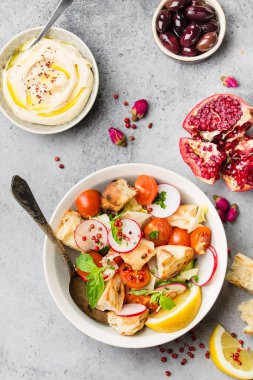 Soğanlı ekmek salata. Orta Doğu/Arapça geleneksel çanak, beton rustik arka plan. Soğanlı salata, Humus, zeytin, pide ekmek. Sağlıklı gıda soğanlı. Orta Doğu/Lübnan öğle yemeği. Üstten görünüm
