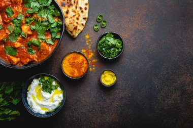 Otantik Hint yemek tavuk tikka masala metin için yer ile. Baharatlı Körili et kase taze ekmek naan, yoğurt raita sosu rustik koyu arka plan, üstten görünüm, yakın çekim, alanı Kopyala 