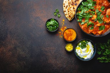 Otantik Hint yemek tavuk tikka masala metin için yer ile. Baharatlı Körili et kase taze ekmek naan, yoğurt raita sosu rustik koyu arka plan, üstten görünüm, yakın çekim, alanı Kopyala 
