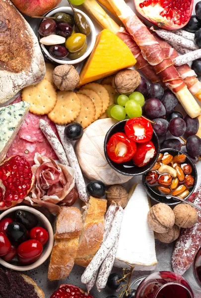 Aperatifler ve mezeler, peynir, et, zeytin, ekmek, meyve, kanepeler, bardaklarda şarap şenlikli gurme karışımı. İtalyan antipasti kümesi veya İspanyolca tapas bar. Gıda paylaşımı, parti veya piknik zaman, top vie