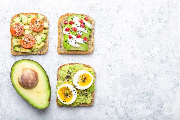 Yumurta, domates, baharat ve beyaz taş arka plan, metin için yer üzerinden tüm avokado yarısını avokado tost. Sağlıklı kahvaltı avokado sandviç farklı soslar, üstten görünüm, yakın-u