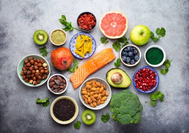 Sağlıklı ürünler ve superfoods: somon, meyve, sebze, meyveler, goji, spirulina, matcha, quinoa, chia tohumu, fındık. Temiz kavramı yeme, gri arka plan, üstten görünüm, yakın çekim