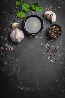 Geleneksel pişirme malzemelerin yakın: sarımsak, zeytinyağı, tuz, biber, taze otlar rustik koyu arka plan üzerinde. Gıda çerçeve, metin, en iyi görünüm için alanı ile sağlıklı yemekler pişirmek için kavramı