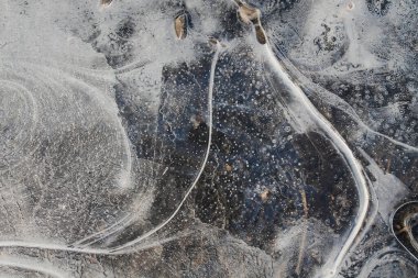 Donmuş su birikintisi. Doku, ince buz. Buz yüzeyi. İnce buz. İlk ince buz tabakası şeffaf ve narin bir su birikintisi üzerinde..