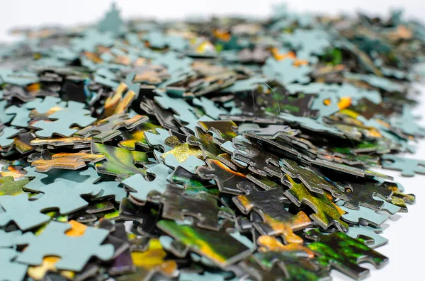 Mantıksal bir yapbozun çok renkli parçaları beyaz arka planda küçük bir yığın içinde