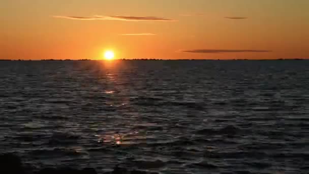 De zon gaat onder de horizon in zee. Tijd verstrijkt. Oranje zonsondergang — Stockvideo