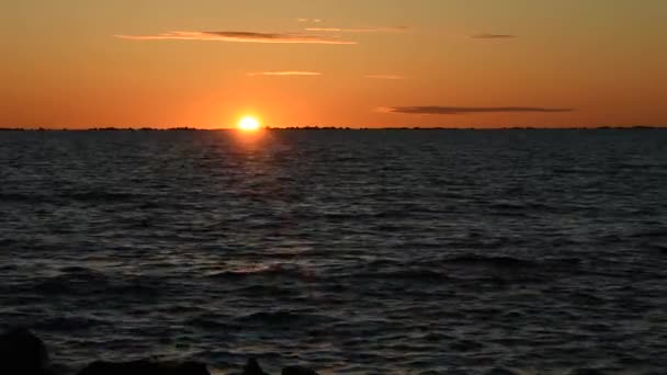 Zon gaat langzaam onder de horizon in zee. Oranje zonsondergang. — Stockvideo